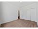 Bright bedroom with neutral carpet, closet, and door leading to stairs at 122 Parmelee Dr. # A, Murrells Inlet, SC 29576
