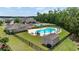 Community pool with lounge seating surrounded by a black fence, landscaping, and trees at 122 Parmelee Dr. # A, Murrells Inlet, SC 29576