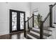 Bright entryway featuring modern doors, staircase with dark wood steps, and stylish decor at 1279 Fiddlehead Way, Myrtle Beach, SC 29579