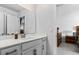 Bathroom featuring a large mirror, white cabinets, and view to bedroom at 1303 Bermuda Grass Dr., Myrtle Beach, SC 29579