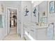 Bright bathroom with a white vanity, decorative mermaid accents, and access to a walk-in closet at 1303 Bermuda Grass Dr., Myrtle Beach, SC 29579