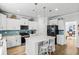 Well-lit kitchen boasts white cabinets, a black refrigerator, and a central island with seating at 1303 Bermuda Grass Dr., Myrtle Beach, SC 29579