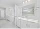 Well-lit bathroom with dual vanities, stylish fixtures, and a view of the glass-enclosed shower at 1303 Bermuda Grass Dr., Myrtle Beach, SC 29579