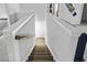 Staircase leading downstairs featuring white walls, wood handrail and tiki bar themed wall art at 1303 Bermuda Grass Dr., Myrtle Beach, SC 29579