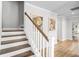 Staircase featuring wood treads and white risers, complemented by stylish nautilus wall art at 1303 Bermuda Grass Dr., Myrtle Beach, SC 29579