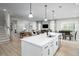 Open-concept kitchen featuring a center island with bar seating and sleek appliances adjacent to living and dining areas at 1312 Piper Glen Dr, Sunset Beach, NC 28468