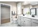 Well-lit bathroom featuring a double sink vanity, and a walk-in closet adjacent to it at 1324 Piper Glen Dr, Sunset Beach, NC 28468