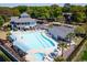 Large community pool with sun loungers, tables, and umbrellas, creating a relaxing outdoor space at 1324 Piper Glen Dr, Sunset Beach, NC 28468