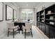 Well-lit home office with built-in bookshelves, a large window, and comfortable seating at 1324 Piper Glen Dr, Sunset Beach, NC 28468