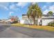 View of the building's exterior surrounded by greenery with a parking area and a palm tree at 1360 Turkey Ridge Rd. # A, Surfside Beach, SC 29575