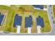 Aerial view showcases the rooftops of new homes, green lawns, and a pond with a paved road at 1372 Palm Springs Paloma Dr, Longs, SC 29568