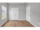 Bright bedroom with wood-look floors, a window, and a closet with double doors at 1372 Palm Springs Paloma Dr, Longs, SC 29568