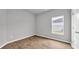 This bedroom features wood-look flooring and a window for natural light at 1372 Palm Springs Paloma Dr, Longs, SC 29568