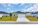 Charming home with light green siding, a modern white garage door, and a neatly kept lawn at 1372 Palm Springs Paloma Dr, Longs, SC 29568