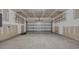Unfinished two-car garage with concrete flooring and door to the home at 1372 Palm Springs Paloma Dr, Longs, SC 29568