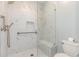 Modern bathroom featuring white marble walls and floors, handrails and a glass shower at 1435 Saint Thomas Circle # E-1, Myrtle Beach, SC 29577