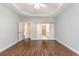 This bedroom includes hardwood floors, white baseboards, tray ceiling with ceiling fan and access to the bathroom at 1435 Saint Thomas Circle # E-1, Myrtle Beach, SC 29577