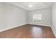This bedroom includes hardwood floors, white baseboards, tray ceiling with ceiling fan and window with shutters at 1435 Saint Thomas Circle # E-1, Myrtle Beach, SC 29577