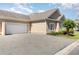 Low angle view of single story home with two car garage and paved driveway at 1435 Saint Thomas Circle # E-1, Myrtle Beach, SC 29577