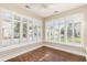 Bright sunroom featuring hardwood floors, ceiling fan, and white plantation shutters offering neighborhood views at 1435 Saint Thomas Circle # E-1, Myrtle Beach, SC 29577