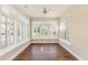 Bright sunroom featuring hardwood floors, ceiling fan, and white plantation shutters offering neighborhood views at 1435 Saint Thomas Circle # E-1, Myrtle Beach, SC 29577