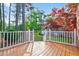 The wooden back deck overlooks a lush, green lawn and beautiful, mature trees at 154 Windsor Circle Sw, Ocean Isle Beach, NC 28469