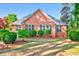 Backyard view of brick house showing manicured bushes and multiple large windows at 154 Windsor Circle Sw, Ocean Isle Beach, NC 28469