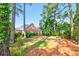 Charming backyard view showcasing the brick home, mature trees, and well-maintained lawn at 154 Windsor Circle Sw, Ocean Isle Beach, NC 28469