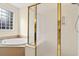 Bathroom featuring a glass-enclosed shower, soaking tub, and a window providing natural light at 154 Windsor Circle Sw, Ocean Isle Beach, NC 28469
