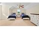 Cozy bedroom featuring twin beds, ceiling fan, and natural light from the window at 154 Windsor Circle Sw, Ocean Isle Beach, NC 28469