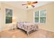 Bright bedroom with hardwood floors, ceiling fan, and large windows offering serene views at 154 Windsor Circle Sw, Ocean Isle Beach, NC 28469