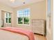 Bright bedroom with hardwood floors and large windows offering views to the landscaped yard at 154 Windsor Circle Sw, Ocean Isle Beach, NC 28469