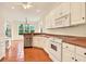 Open-concept kitchen with stainless steel appliances, white cabinetry, and tile floors at 154 Windsor Circle Sw, Ocean Isle Beach, NC 28469