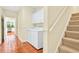 Convenient laundry area with washer, dryer, and storage cabinets near stairs and the kitchen at 154 Windsor Circle Sw, Ocean Isle Beach, NC 28469