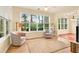 Bright sunroom with hardwood floors, comfortable seating, and large windows offering garden views at 154 Windsor Circle Sw, Ocean Isle Beach, NC 28469