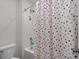 A shower/tub with colorful polka-dot shower curtain and white ceramic tiling at 155 S Reindeer Rd., Surfside Beach, SC 29575