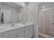 Bright bathroom features double sinks with white cabinetry and a walk-in shower at 155 S Reindeer Rd., Surfside Beach, SC 29575