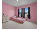 A cheerful bedroom with pink walls, plush carpeting and light from the large windows at 155 S Reindeer Rd., Surfside Beach, SC 29575