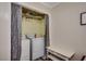 Practical laundry area with a washer, dryer, shelving, and a convenient small bench at 1582 S Waccamaw Dr. # 34, Garden City Beach, SC 29576