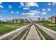 Walkway leading to the building with lush green grass, palm trees, and a clear blue sky at 1582 S Waccamaw Dr. # 34, Garden City Beach, SC 29576