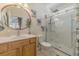 Bright bathroom featuring a wooden vanity, round mirror, and a glass-enclosed shower at 1614 Cottage Cove Circle, North Myrtle Beach, SC 29582