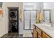 Bathroom with vanity, shower, and a stackable washer and dryer hidden in closet at 1614 Cottage Cove Circle, North Myrtle Beach, SC 29582
