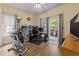 A light and bright flex room with an outside patio, exercise equipment, desk, and hardwood floors at 1614 Cottage Cove Circle, North Myrtle Beach, SC 29582