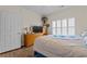 This bedroom features wood floors, a window with shutters, a TV, and a bed with blue accents at 1614 Cottage Cove Circle, North Myrtle Beach, SC 29582