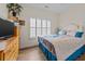 This bedroom features wood floors, a window with shutters, a TV, and a bed with blue accents at 1614 Cottage Cove Circle, North Myrtle Beach, SC 29582