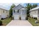 Two-story home with gray siding, two-car garage, well-manicured lawn, and lush, mature trees at 1614 Cottage Cove Circle, North Myrtle Beach, SC 29582
