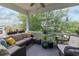 Relaxing screened-in porch featuring comfortable wicker furniture and serene views of the surrounding greenery at 1614 Cottage Cove Circle, North Myrtle Beach, SC 29582