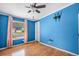Vibrant blue bedroom featuring wood floors, a window, and a ceiling fan at 1894 Athens Dr., Conway, SC 29526