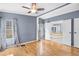 A blue bedroom includes a ceiling fan and an entrance to a large primary bathroom at 1894 Athens Dr., Conway, SC 29526