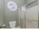 Bathroom featuring a toilet, shower with glass doors, and a decorative octagon-shaped window at 212 Greenwich Dr., Conway, SC 29526